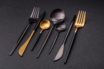 Cutlery fork, knife and spoon on a dark textured concrete background