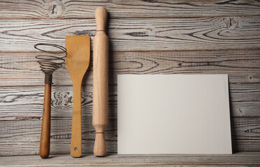 White card and Set of wooden eco kitchen utensils on boards.