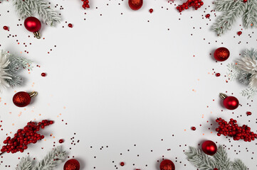 Christmas composition, fir tree branches, red berries, baubles and stars confetti on white background. Christmas, New Year, winter concept. Top view, flat lay, copy space.