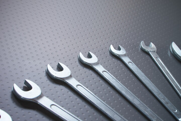 Assorted Wrenches on Dotted Metal Surface Highlighting Mechanical Tools