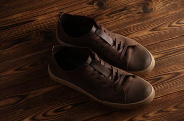 Used leather sneakers on a wooden background