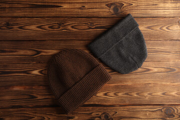 Various winter hats on a wooden background. Top view