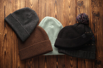 Various winter hats on a wooden background. Top view