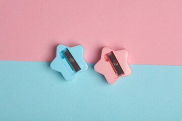 Two sharpeners in the shape of stars on a blue-pink pastel background