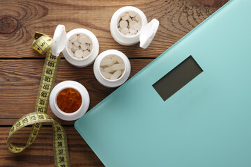 Weight loss concept. Bottles of pills, measuring tape and bathroom scales. Top view