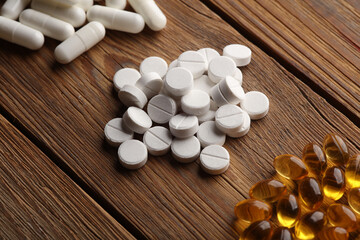 Different types of pills on a wooden table