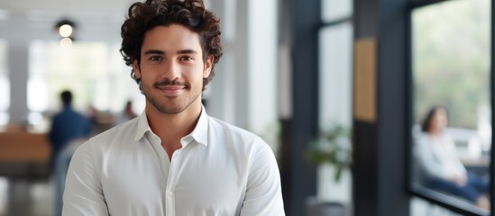 Obraz premium Young Hispanic male psychologist looks confident while smiling at psychology center