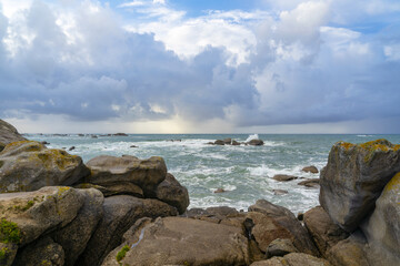Fototapeta na wymiar Côte rocheuse, mer agitée sous un ciel très nuageux : l'âme tourmentée du littoral breton.