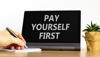 Pay yourself first symbol. Concept words Pay yourself first on beautiful tablet screen. Beautiful wooden table white background. Businessman hand. Business and pay yourself first concept. Copy space. - obrazy, fototapety, plakaty