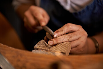 Carving, wood and hands of artist with tools in workshop for creative project or process of...