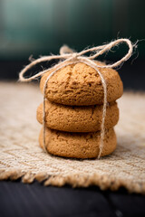 Oatmeal cookies tied with a rope on a wooden table. The concept of food for breakfast