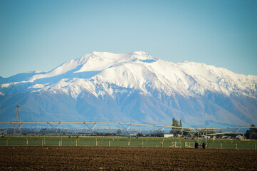 Naklejka premium Snow-capped Mountain with Pivot Irrigation in the foreground