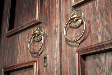 Vintage Wooden Door with Ornate Brass Knockers and Keyhole Detail