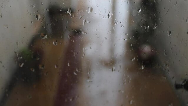 Gotas de lluvia sobre el vidrio transparente de la ventana de la casa, de un d&iacute;a lluvioso crea burbujas que se deslizan por la superficie formando un bello dise&ntilde;o abstracto con fondo desenfocado