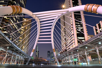 Bangkok, Thailand, Skywalk train bridge in business district. Colorful sky and beautiful scenery of cityscape at night