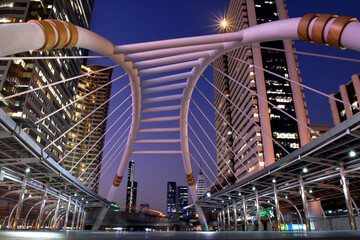 Bangkok, Thailand, Skywalk train bridge in business district. Colorful sky and beautiful scenery of cityscape at night