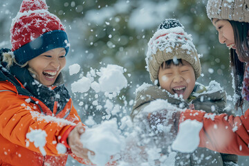 Winter wonder: Asian family having a snowball fight, laughter and joy amidst a snowy landscape, winter apparel 