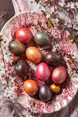 Eggs painted in different colors and covered with mother-of-pearl, and blossoming plum branches. Easter concept. - 753244289