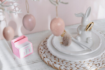 Table place setting with easter bunny figure, eggs and wooden Perpetual calendar