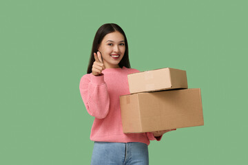 Pretty young woman with parcels pointing at viewer on green background