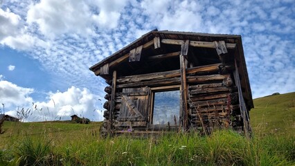 Cute old wooden house in the Alps. Summer landscape