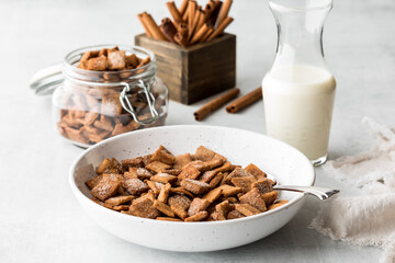 A bowl of homemade low carb cinnamon toast crispy cereal served with fresh milk.