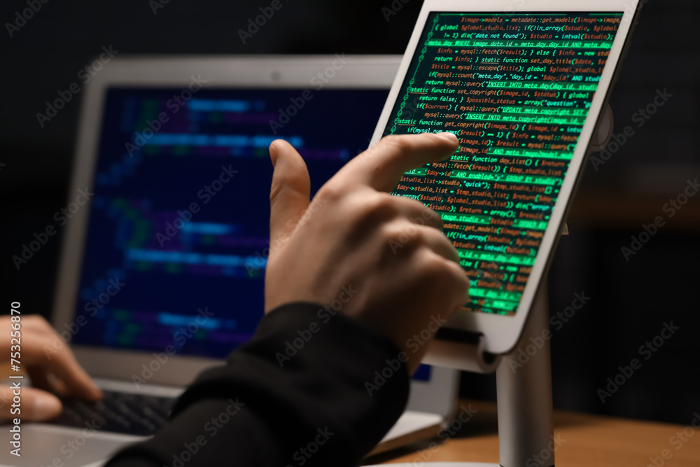 Aufkleber hacker using tablet computer in dark room, closeup