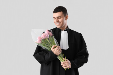 Male judge with tulips on light background. International Women's Day celebration