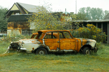 Old abandoned rusty vehicle, crushed car in scrapyard. metal recycling concept. junk yard needed to...