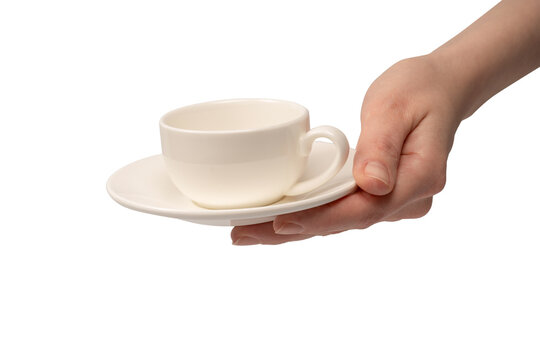 Female hand holding coffee cup and saucer isolated on white background.