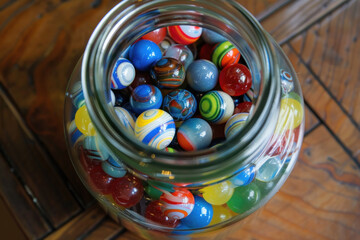  Jar full of colorful marbles on a wooden surface.