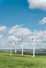 Sustainable energy generation with modern windmills in a green field under a blue sky - 753266606