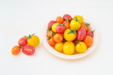 Fresh small persimmons of various colors on white background