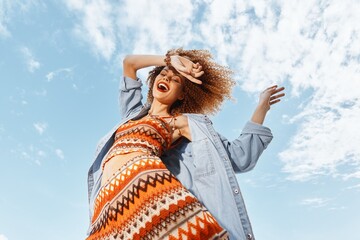 Smiling Woman Dancing on a Beach, Embracing the Freedom of a Hippie Lifestyle