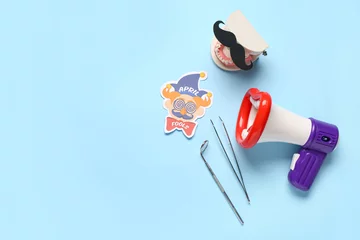 Fotobehang Model of jaw with paper mustache, megaphone and dentist tools on blue background. April Fools Day © Pixel-Shot