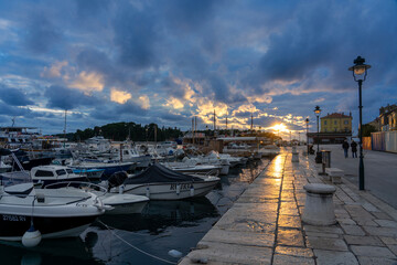 Fototapeta na wymiar boats in the harbor in Rovinj in the evening with adriatic sea and sunset