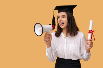 Female student in graduation hat with diploma and megaphone on orange background