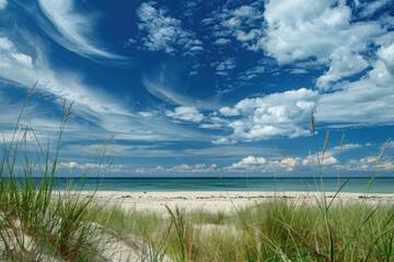 Pristine beach with white sand, dune grass, and a stunning blue sky with wispy clouds.