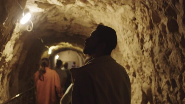 Tourists descend through a tunnel into an underground bunker in a cave