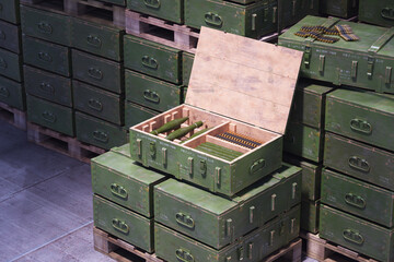 Stacked Military Ammo Boxes with Exposed Bullets on Wooden Pallets