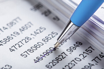 Fototapeta premium Accounting document with pen, money, coins and checking financial chart. Concept of banking, financial report and financial audit.