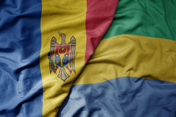 big waving national colorful flag of gabon and national flag of moldova .
