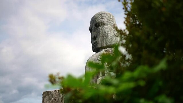 Maori statue at Wairakei Terraces in New Zealand. Silica terraces, geothermal and mineral hot pools.