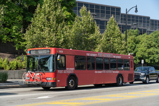 Pittsburgh, Pennsylvania – July 23,2023:  A Port Autority red city bus with bicycle on Forbes Ave. in Pittsburgh, Pa