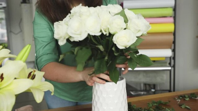 Small business. Female florist unfocused in flower shop. Floral design studio, making decorations and arrangements. Flowers delivery, creating order.