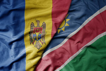 big waving national colorful flag of namibia and national flag of moldova .