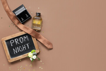 Chalkboard with text PROM NIGHT, cufflinks and perfume bottle on brown background