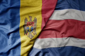 Fototapeta premium big waving national colorful flag of costa rica and national flag of moldova .