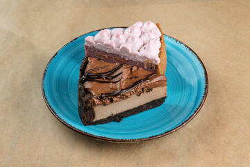 A slice of cherry cheesecake and a slice of chocolate cheesecake on a blue plate.