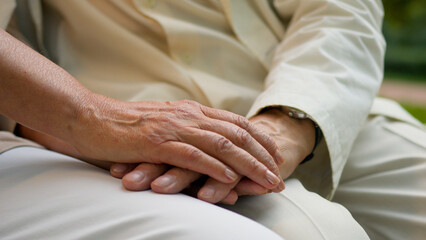 Close up unrecognizable wrinkled hand elderly old senior aged man and woman married couple husband wife holding hands outside love support family expressing empathy understanding relationship marriage